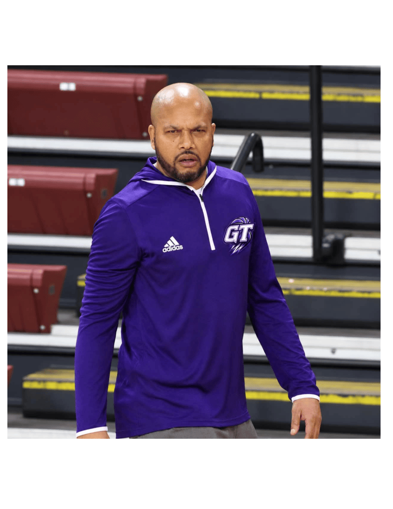 Coach J, Julian Goodson, courtside in a purple Goodson Training quarter-zip